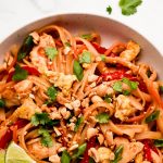 Chicken Pad Thai in a bowl and garnished with peanuts and cilantro.